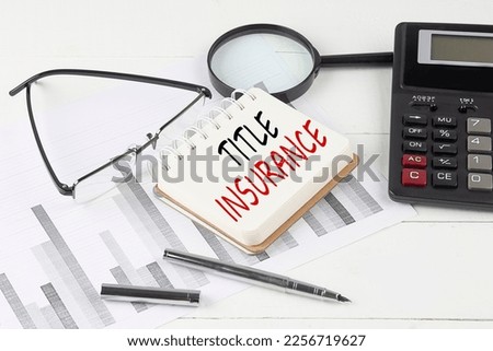 TITLE INSURANCE text on a notebook with calculator on diagram background