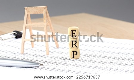 wooden cubes with the word ERP stand on financial background, business concept.
