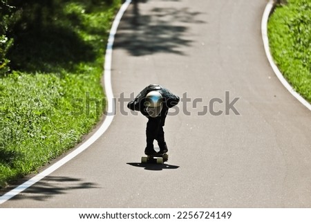 Cinematic downhill longboard session. Young man skateboarding and making tricks. Concept about extreme sports and people