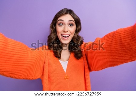 Photo of positive cheerful lady wear orange clothes make picture post good mood isolated on purple color background