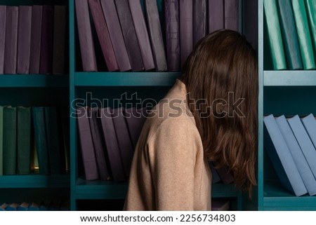 Sad student on the background of bookshelves. Exam stress. academic failures and loss of motivation.