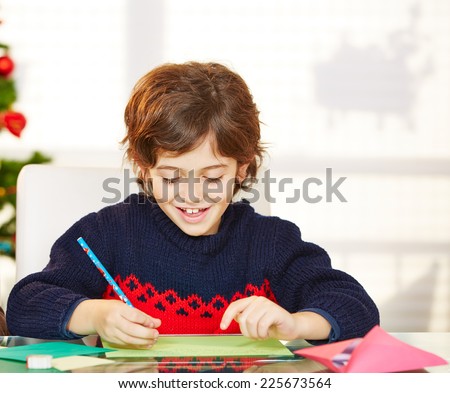 Happy boy writing his wishlist for christmas eve