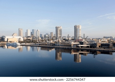 The morning view of calm waters reflecting buildings and a cruise ship terminal with Tampa downtown skyline in a background (Florida).