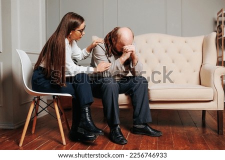 anxious troubled senior Caucasian bald man with caring young female nurse psychologist, Senior man therapy at home. rehabilitation therapy, physical therapist, physician consulting, upset, tired,