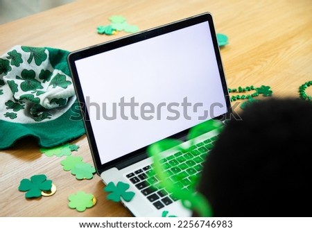 High angle view of african american man on video call through laptop with copy space. unaltered, people, lifestyle, technology and st patrick's day celebration concept.
