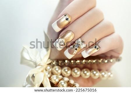 Pearl French manicure with rhinestones and embellishments. Royalty-Free Stock Photo #225675016