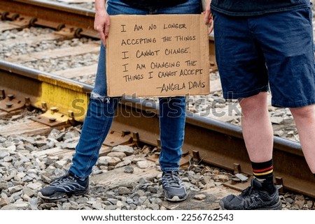 A protestor holds a sign with an Angela Davis quote on it at a Black Lives Matter rally.  Royalty-Free Stock Photo #2256762543