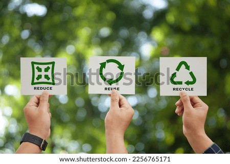 Hand holding reduce, reuse, recycle symbol on green bokeh background. Ecological and save the earth concept. An ecological metaphor for ecological waste management and a sustainable. Royalty-Free Stock Photo #2256765171