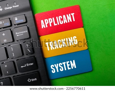 Black wireless keyboard with the word APPLICANT TRACKING SYSTEM Royalty-Free Stock Photo #2256770611