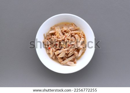 Indonesian traditional food named "tumis gori pedas" i.e. sauteed slices of young jackfruit with chili pepper and spices served on bowl isolated on gray background, top view Royalty-Free Stock Photo #2256772255