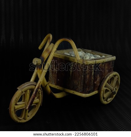 wooden Tricycle toy isolated in black pattern background.