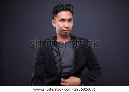 Asian male in corporate oufit over dark background.  Office business concept.