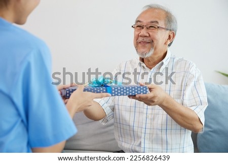senior man giving present or gift from caregiver for happy birthday