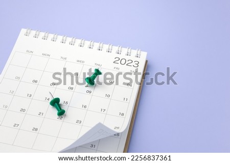 Calendar 2023 with pinned date on purple background, planning and scheduling or event reminder concept