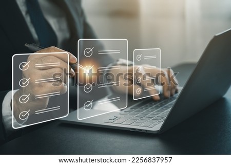 Electronic signature or checking list, Business man using pen checking digital virtual screen document, document management, paperless office, signing business contract, electronic document system. Royalty-Free Stock Photo #2256837957