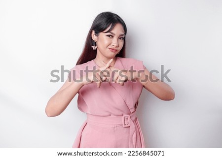 Beautiful Asian woman wearing pink blouse with hand gesture pose rejection or prohibition with copy space