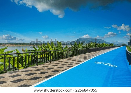Cycling path along the Mekong River Chiang Khan District, Thailand,Marking a bike path on the sidewalk, Blue lane with signs of bicycles and walkway for walkers at riverside park
