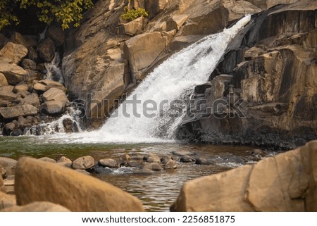 A short water fall flowing over rocks