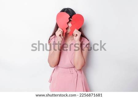 Beautiful young Asian woman expressed her sadness while holding broken heart isolated on white background Royalty-Free Stock Photo #2256871681