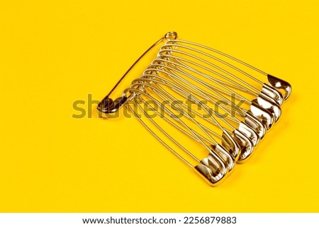 A set of pins on a yellow background. A set of metal pins.