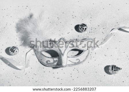 Carnival mask with balls and confetti on light background