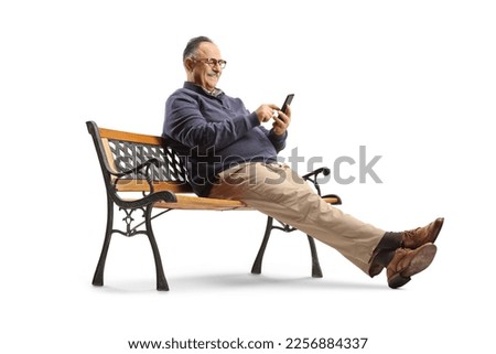 Mature man sitting on a bench and using a smartphone isolated on white background Royalty-Free Stock Photo #2256884337