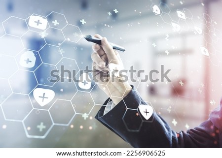 Double exposure of male hand with pen working with abstract virtual medical hologram on blurred office background. Healthcare technolody concept