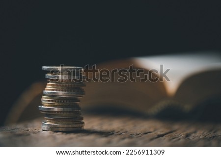 One tenth or tithe is basis on which Bible teaches us to give one tenth of first fruit to God. coins with Holy Bible. Biblical concept of Christian offering, generosity, and giving tithes in church. Royalty-Free Stock Photo #2256911309