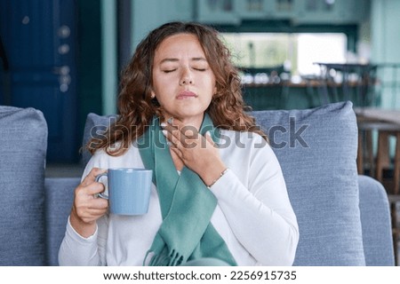 Young woman touching painful neck, sore throat for flu, cold and infection Royalty-Free Stock Photo #2256915735