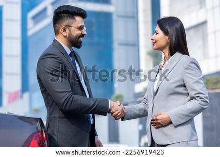 Business people shaking hands outside office building Royalty-Free Stock Photo #2256919423
