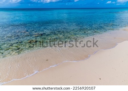 A view out to sea along the shoreline on a quiet beach on the island of Eleuthera, Bahamas on a bright sunny day Royalty-Free Stock Photo #2256920107