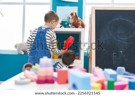 Adorable caucasian boy holding pin bowling standing at kindergarten