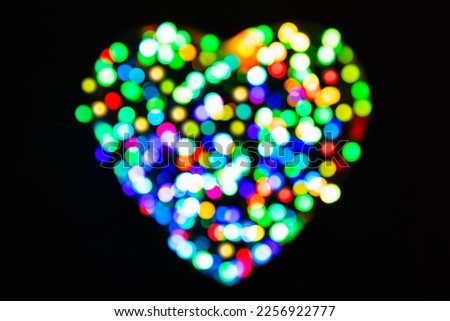 Rainbow confetti from the light with a bokeh effect in the shape of a heart on a black background (Valentines Day backdrop) Royalty-Free Stock Photo #2256922777