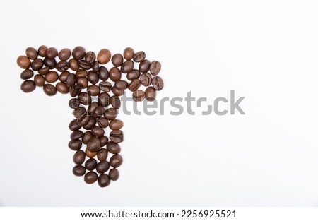 T is a capital letter of the English alphabet made up of natural roasted coffee beans that lie on a white background. Plenty of space to put text or pictures, top view and studio photography.