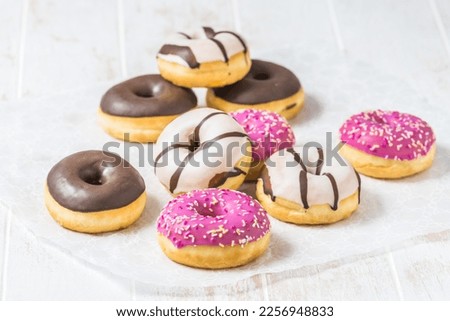 Colorful Donuts, Berliner, Krapfen with sugar icing and chocolate on white wooden background, vertical with copy space Royalty-Free Stock Photo #2256948833
