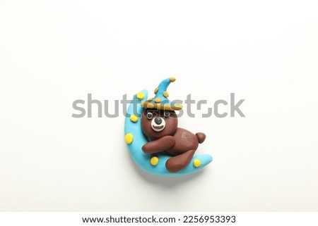 Beautiful bear and moon made of plasticine on white background, top view