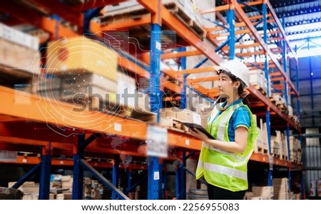Storage worker in uniform and notepad,digital tablet in hands checks production. warehouse concept  with  virtual icon diagram
