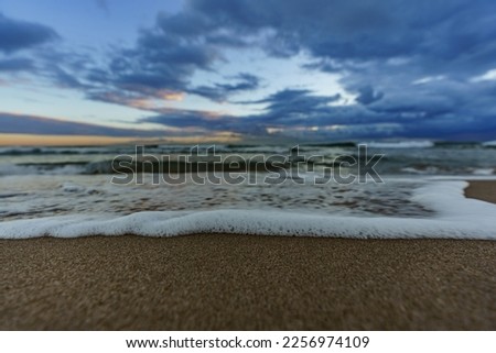 Beautifully blurred sea waves against the sandy shore of the sea