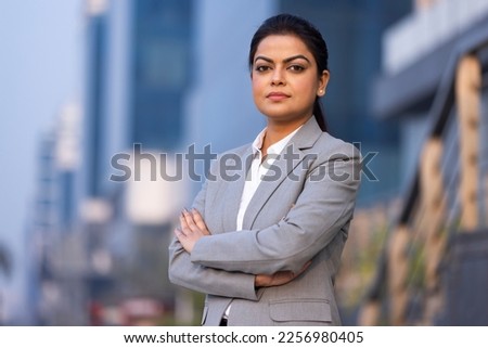 Young woman in business wear standing with armes crossed in business environment, Royalty-Free Stock Photo #2256980405