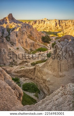 The view of the rugged yet beautiful Notch Trail at Badlands National Park in South Dakota at sunset. The park’s 244,000 acres protect an expanse of mixed-grass prairie and striking geologic deposits. Royalty-Free Stock Photo #2256983001