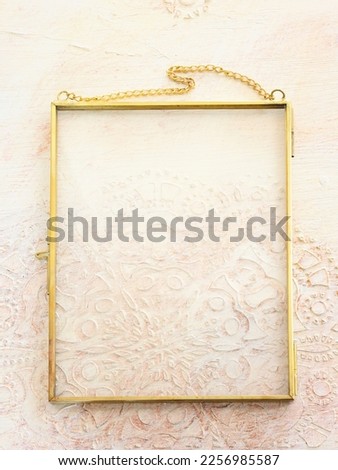 Image of gold tone metal vintage empty photo frame over textured white wooden background. For mockup, can be used for photography montage