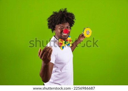 handsome, happy black man playing a tambourine in carnival clothes