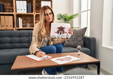 Young blonde woman psychologist having rorscharch test at psychology center