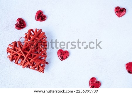big red heart and lots of little hearts on a white background. The concept of Valentine's Day. Place for text Royalty-Free Stock Photo #2256993939