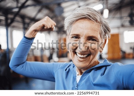 Senior woman, flexing and smile for selfie or profile picture in exercise, workout or muscle training at the gym. Portrait of happy elderly female in fitness smiling for vlog, social media or post