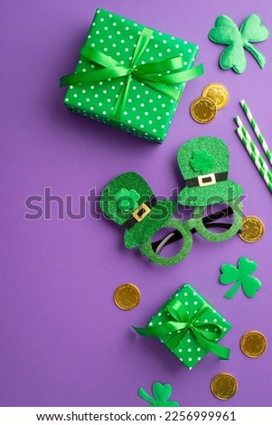 Saint Patrick's Day concept. Top view vertical photo of green gift boxes hat shaped party glasses gold coins straws and clovers on isolated lilac background