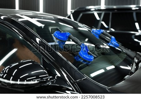 Glass of the car is a close-up in the room, removed with the help of professional suction cups. The process of car repair