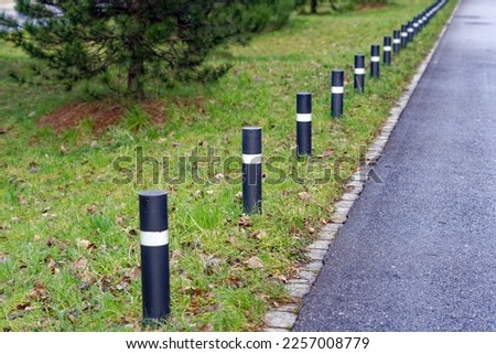 Metal border poles with reflectors at pavement of City of Zürich district Oerlikon on a winter noon. Photo taken January 31st, 2023, Zurich, Switzerland.