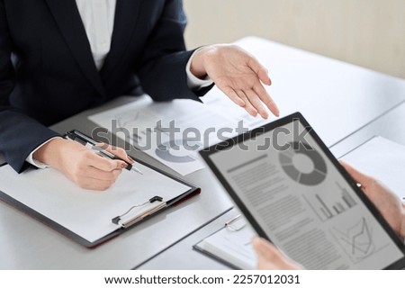 Asian business woman showing and explaining a tablet Royalty-Free Stock Photo #2257012031