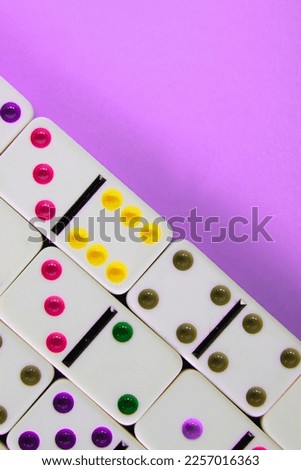 Close up view of white dominoes on violet background.